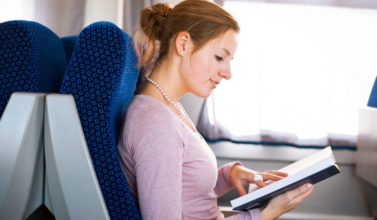 Passageira lê livro em voo de avião