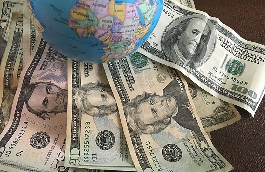 Notas de dólar espalhadas por mapa mundi