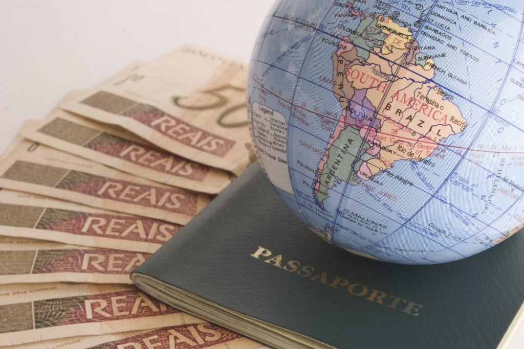 Notas de real embaixo de passaporte brasileiro