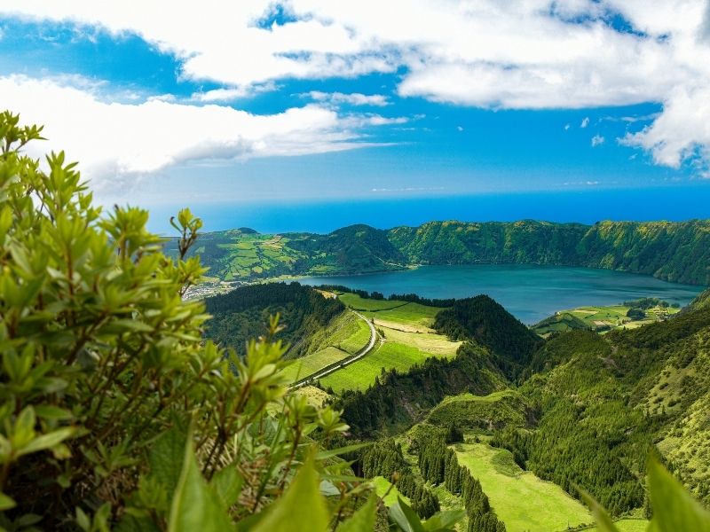 Vista de campos verdes e lagoa em Açores