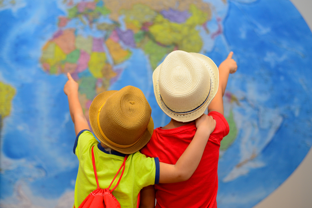 Crianças apontam para mapa mundi
