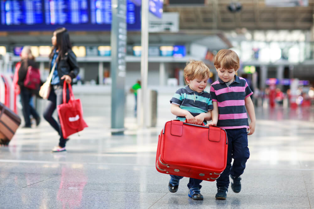 Crianças com malas em aeroporto