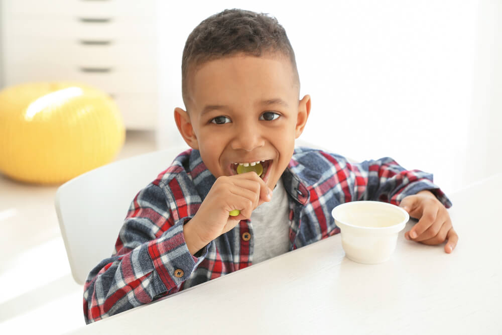 Criança segura colher comendo