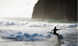 Surfista praticando o esporte ao entardecer em fernando de noronha
