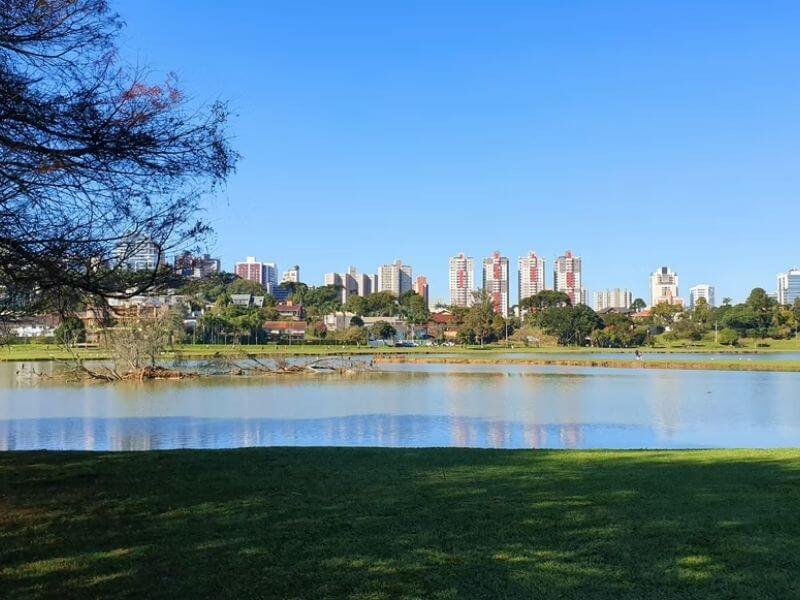 Vista de um lago e da cidade de Curitiba aos fundos