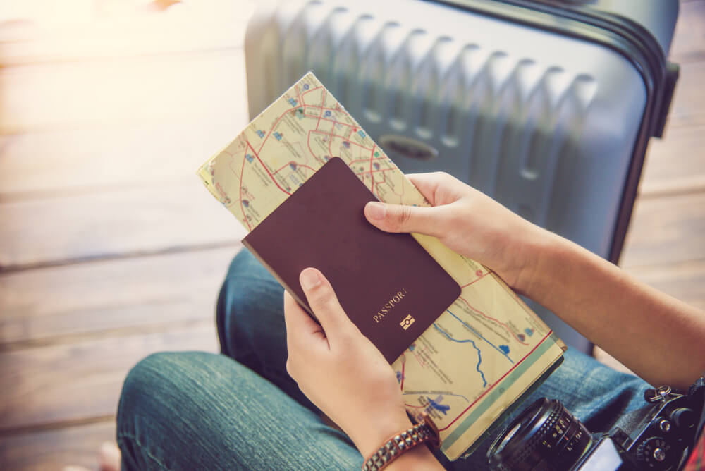 Turista segura passaporte com mapa de viagem em aeroporto
