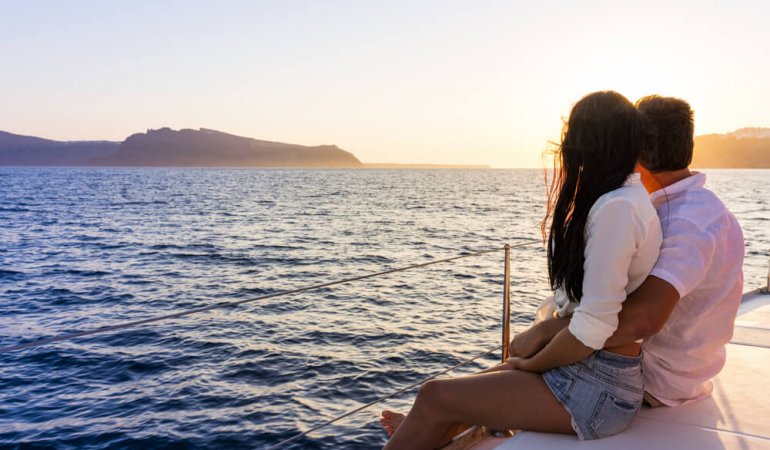 Casal em viagem de barco pelo mar