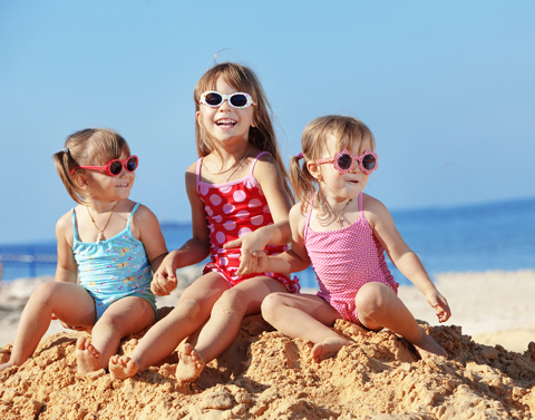 Crianças irmãs brincam na areia da praia