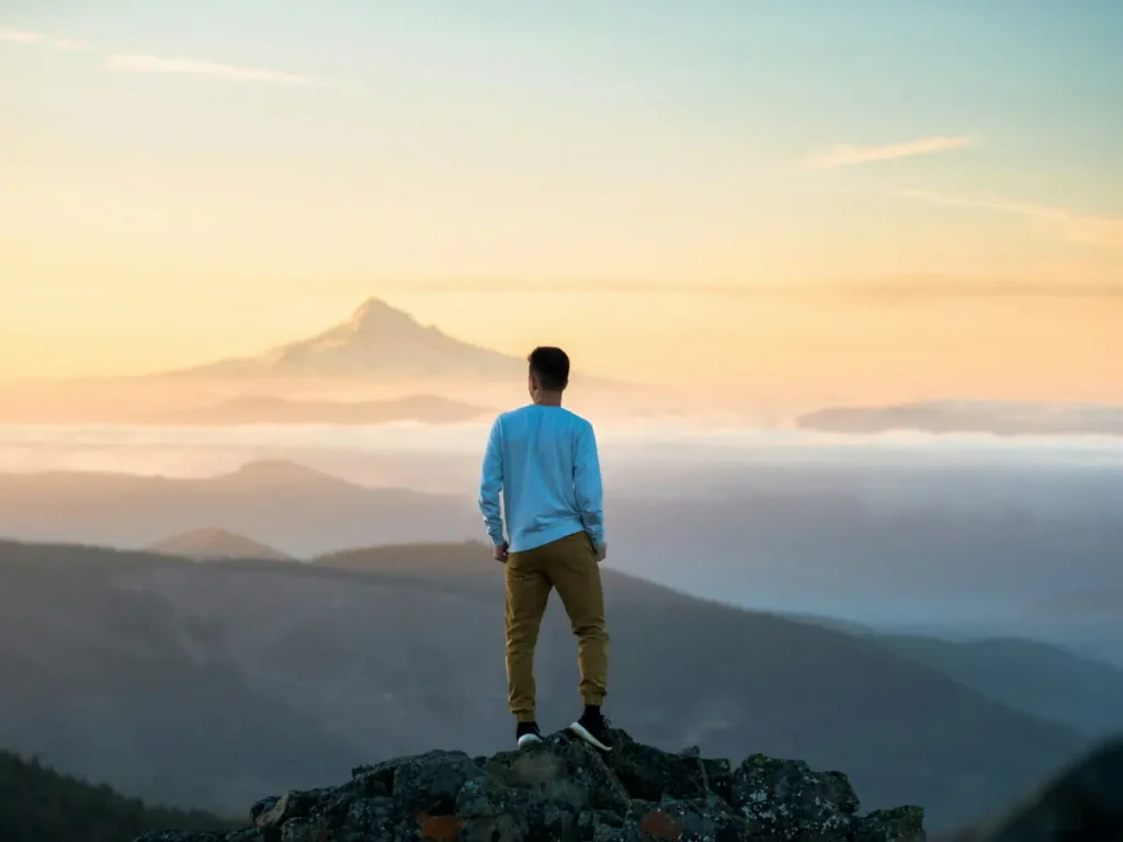 Jovem observando a paisagem, representando lugares para viajar sozinho.