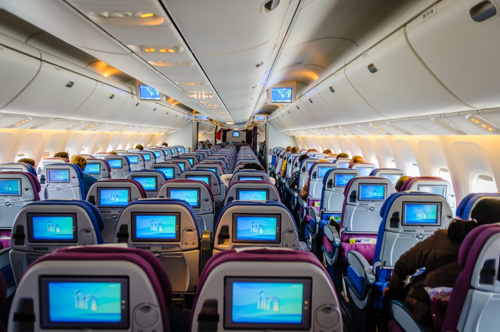 Foto de uma cabine de avião com os assentos desocupados. Disponível no Unsplash