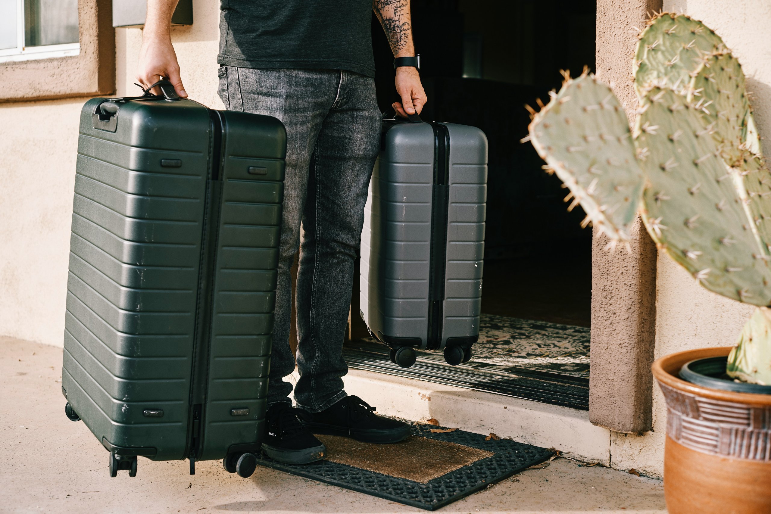 Homem segura malas de viagem. Foto disponível no Unsplash