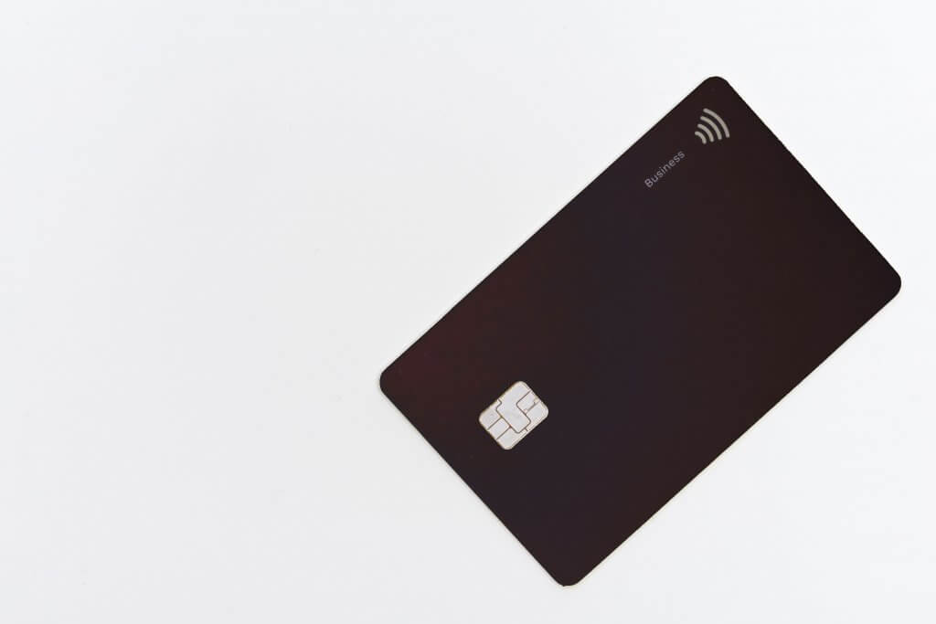 Cartão de crédito preto, sobre fundo branco. Imagem disponível no Unsplash