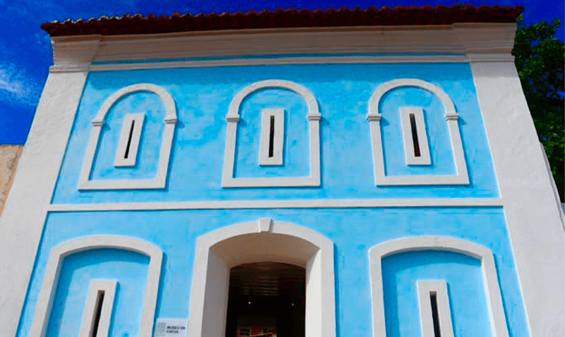 prédio azul com janelas com molduras brancas e ovais