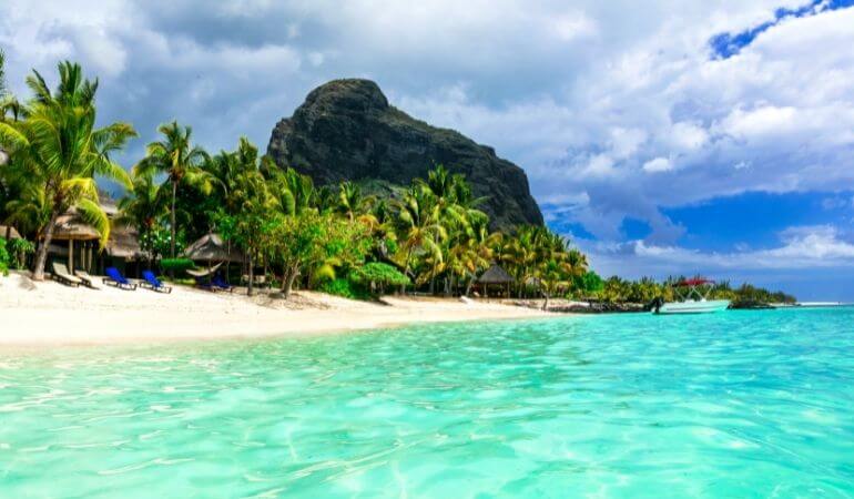Vista de frente de Ilhas Maurício, das águas, praia, vegetação e montanhas