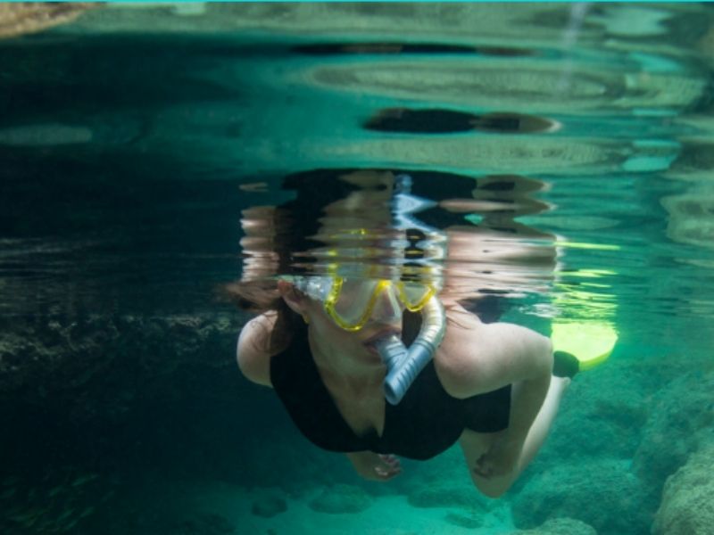 Mulher fazendo mergulho em Fernando de Noronha