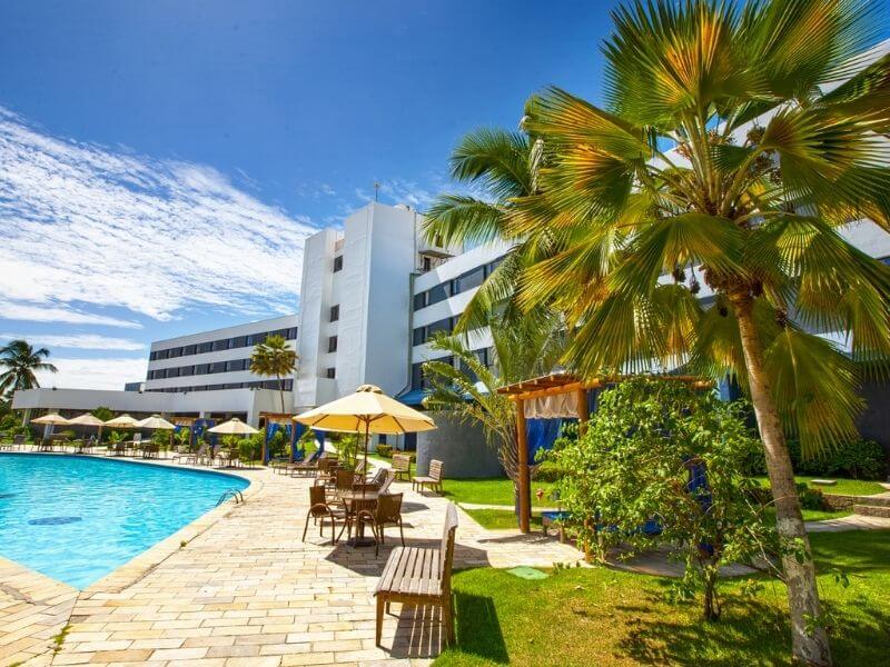 Área externa da piscina e palmeiras do Del Mar Hotel em Aracaju