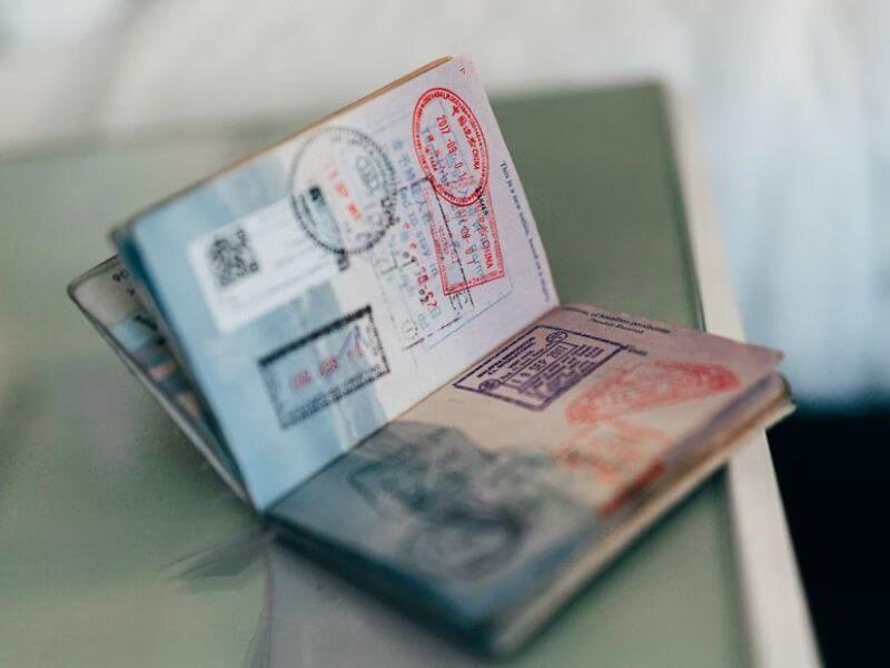 Passaporte aberto com vários carimbos, capa do conteúdo sobre ETIAS Europa