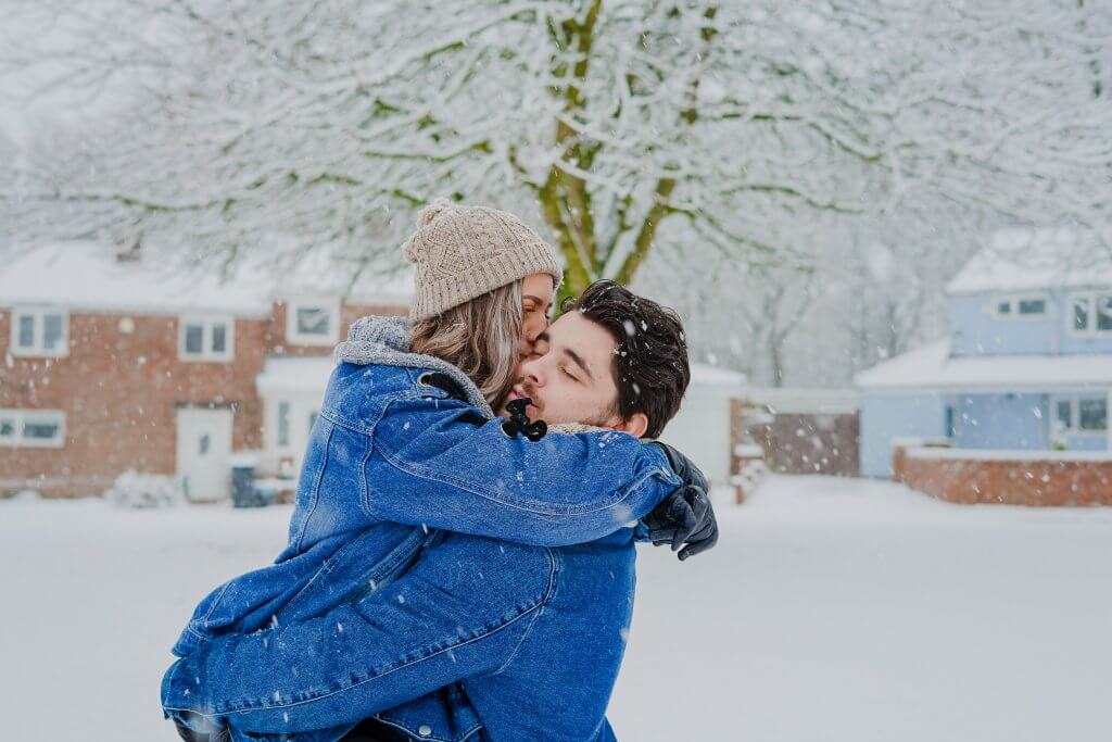 casal em lua de mel no inverno, na neve, se abraçando