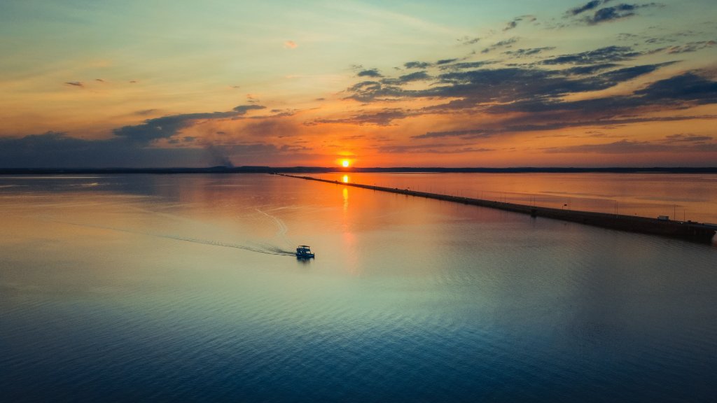 Pôr do sol em um lago, em Palmas. Imagem disponível em Unsplash.