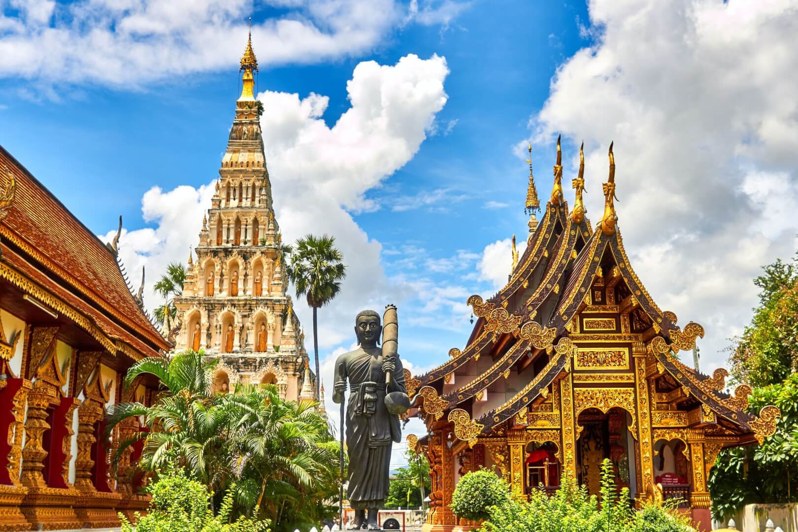 Templos dourados e estátua de concreto tailandeses. Imagem disponível em Unsplash.