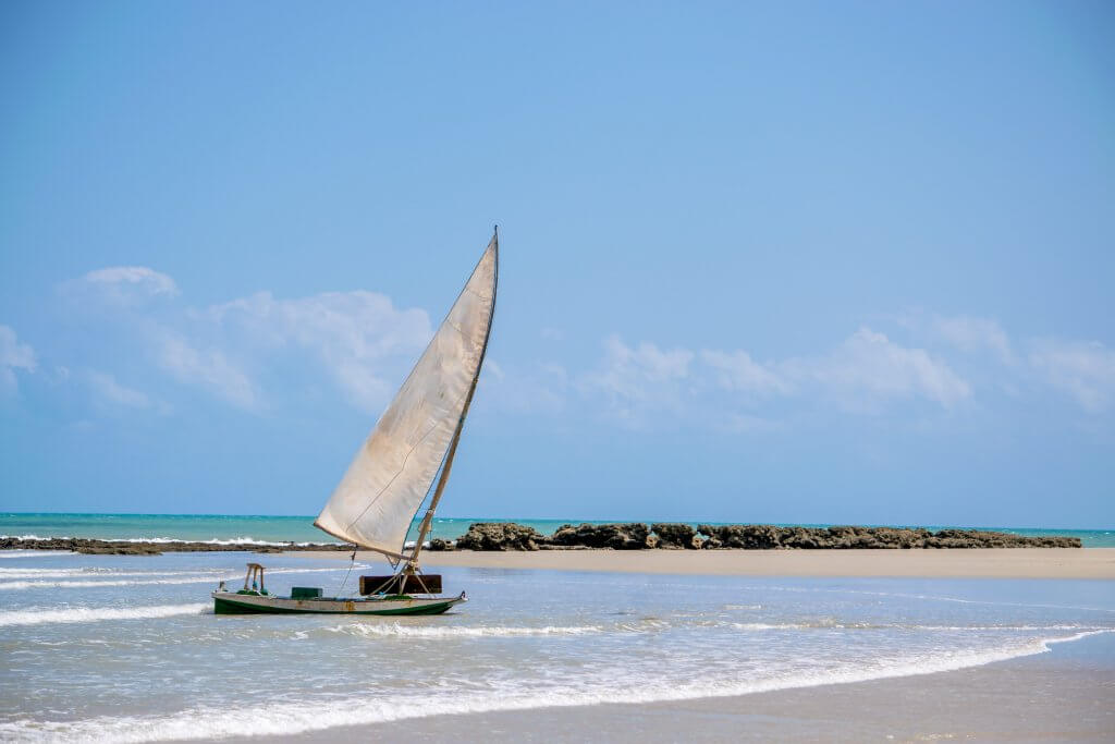 Jangada chega na areia da praia em São Miguel do Gostoso. Imagem disponível em Shutterstock.